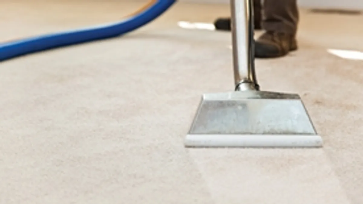 Carpet cleaning wand head gliding over a light carpet during hot-water extraction, Milwaukee, WI.