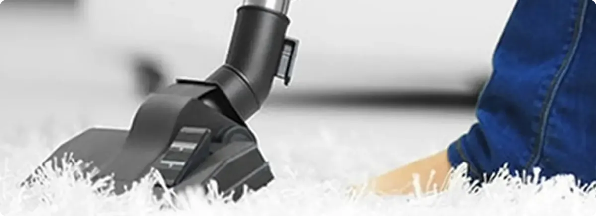 Close-up of a professional vacuuming a white carpet in Butler.